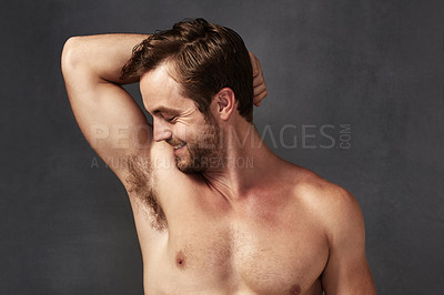 Buy stock photo Cropped shot of a handsome young man smelling his armpits