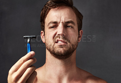 Buy stock photo Man, doubt or shaving with razor for health, skincare or disgust for hair removal in studio. Beard, face or model holding blade for cleaning, thinking or frown for problem isolated on gray background