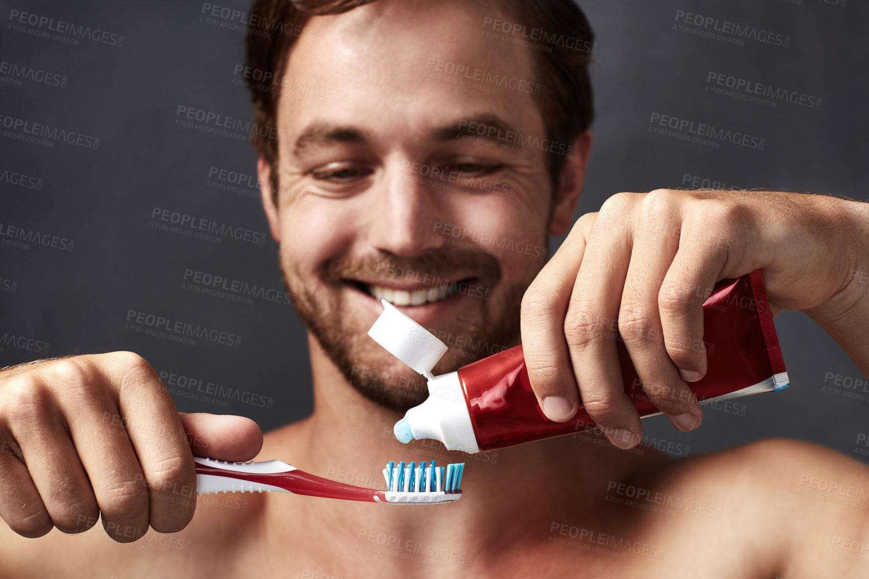 Buy stock photo Brushing teeth, hands and smile with man in studio isolated on blue background for dental care. Toothbrush, toothpaste and product with happy person in bathroom, cleaning mouth for protection
