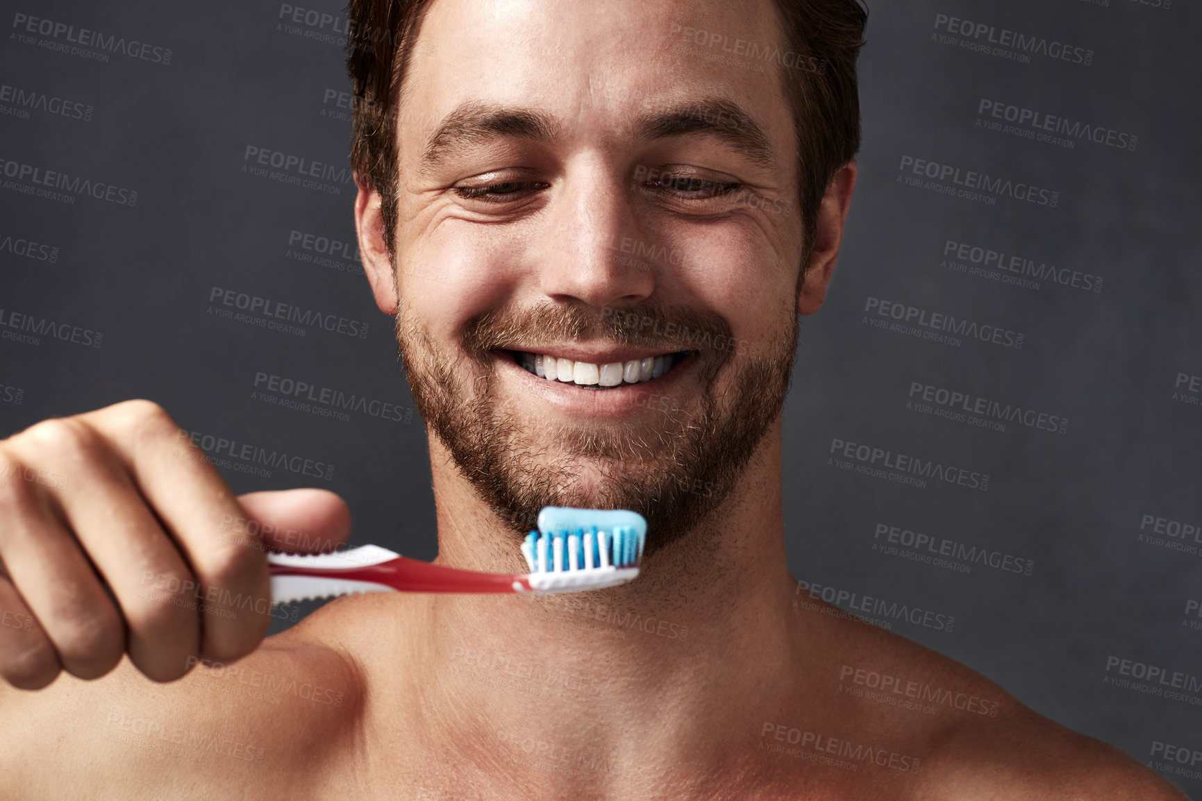Buy stock photo Cropped shot of a handsome young man brushing his teeth against a grey background