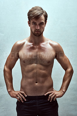 Buy stock photo Shot of a handsome bare-chested young man posing in the studio