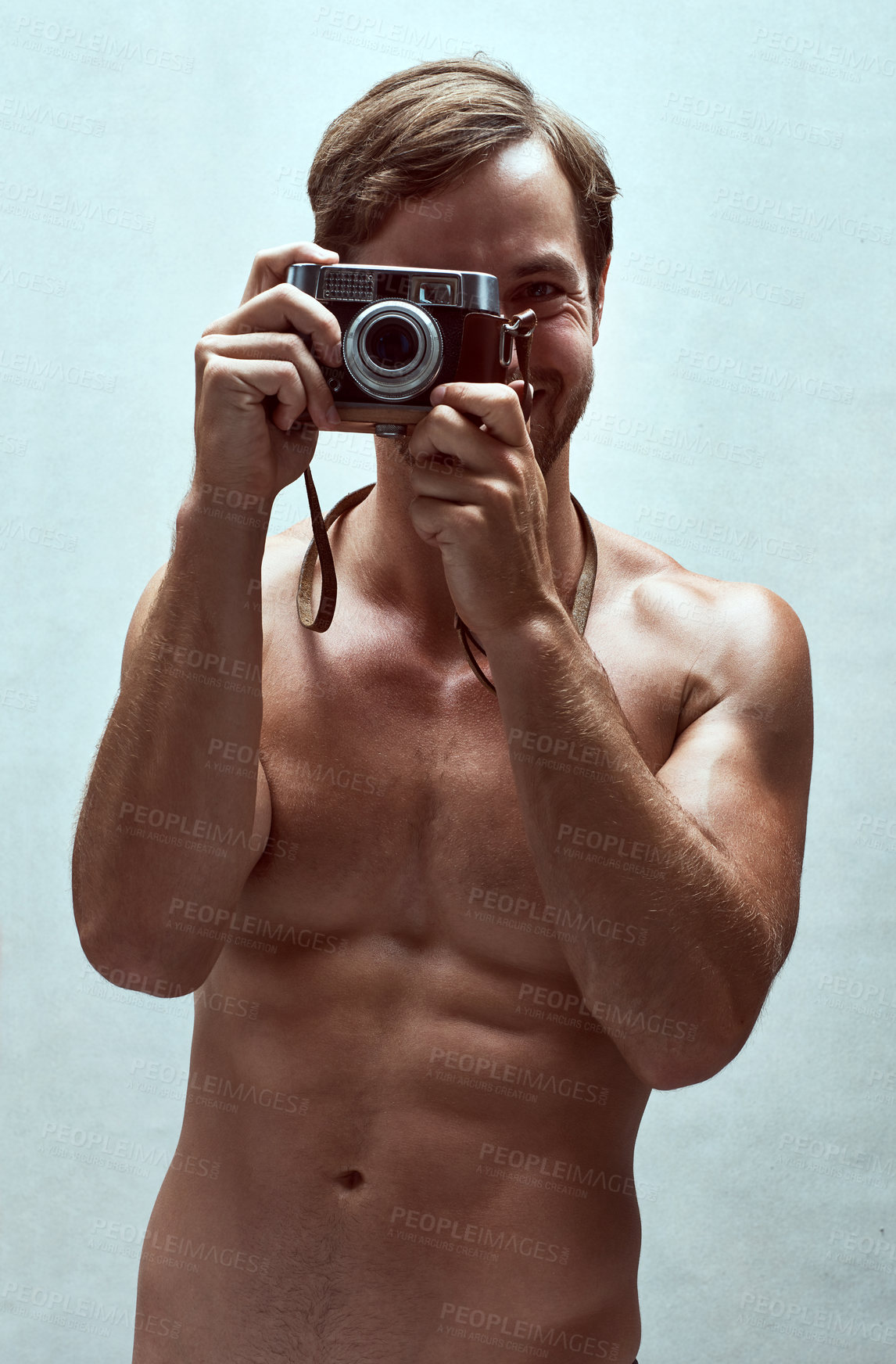 Buy stock photo Cropped shot of a handsome young man posing with a camera