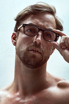 Buy stock photo Cropped shot of a handsome young man posing with reading glasses