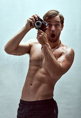 Buy stock photo Cropped shot of a handsome young man posing with a camera