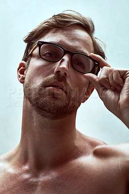 Buy stock photo Cropped shot of a handsome young man posing with reading glasses