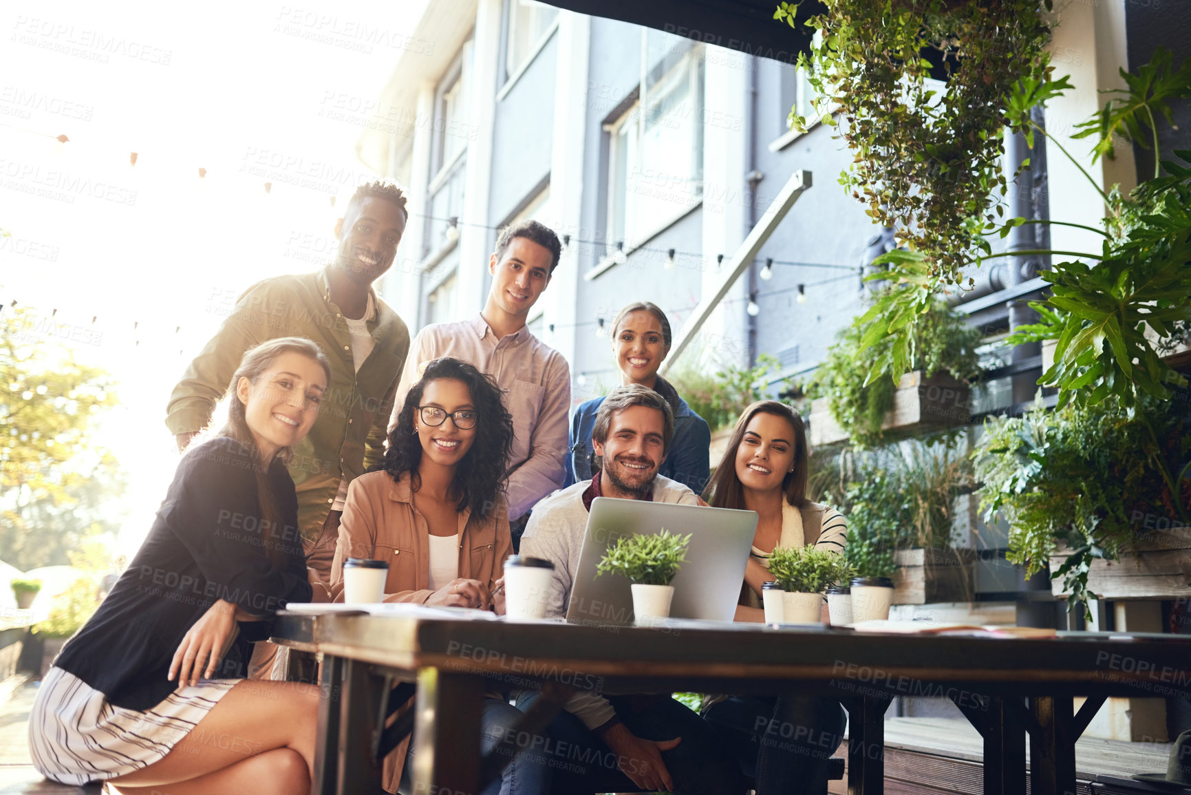 Buy stock photo Cropped portrait of a team of colleagues using a laptop together during a meeting at an outdoor cafe