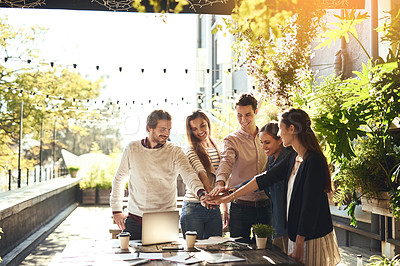 Buy stock photo Cropped shot of a group of colleagues joining hands in agreement during a meeting at an outdoor cafe