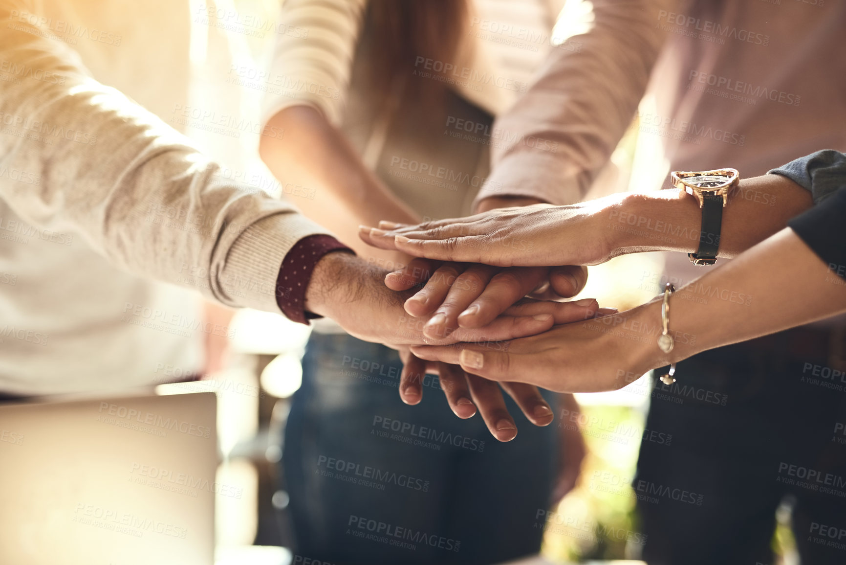 Buy stock photo Cropped shot of a group of colleagues joining hands in solidarity outdoors