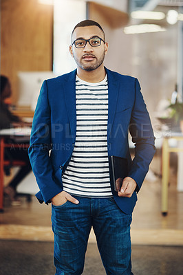 Buy stock photo Shot of a handsome young businessman standing in an office