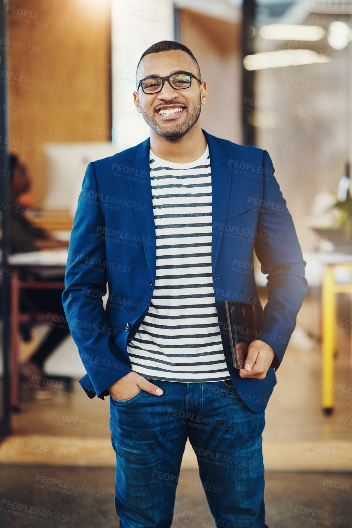 Buy stock photo Shot of a handsome young businessman standing in an office