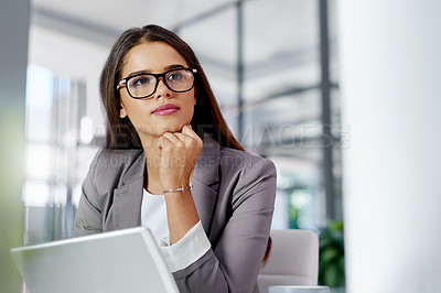 Buy stock photo Cropped shot of a young businesswoman looking thoughtful while working in an office