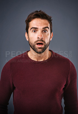 Buy stock photo Studio shot of a handsome young man looking surprised against a gray background