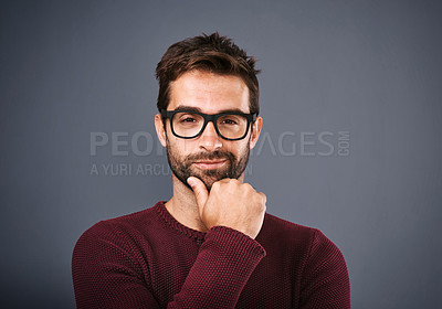 Buy stock photo Studio shot of a handsome young man looking smug against a gray background