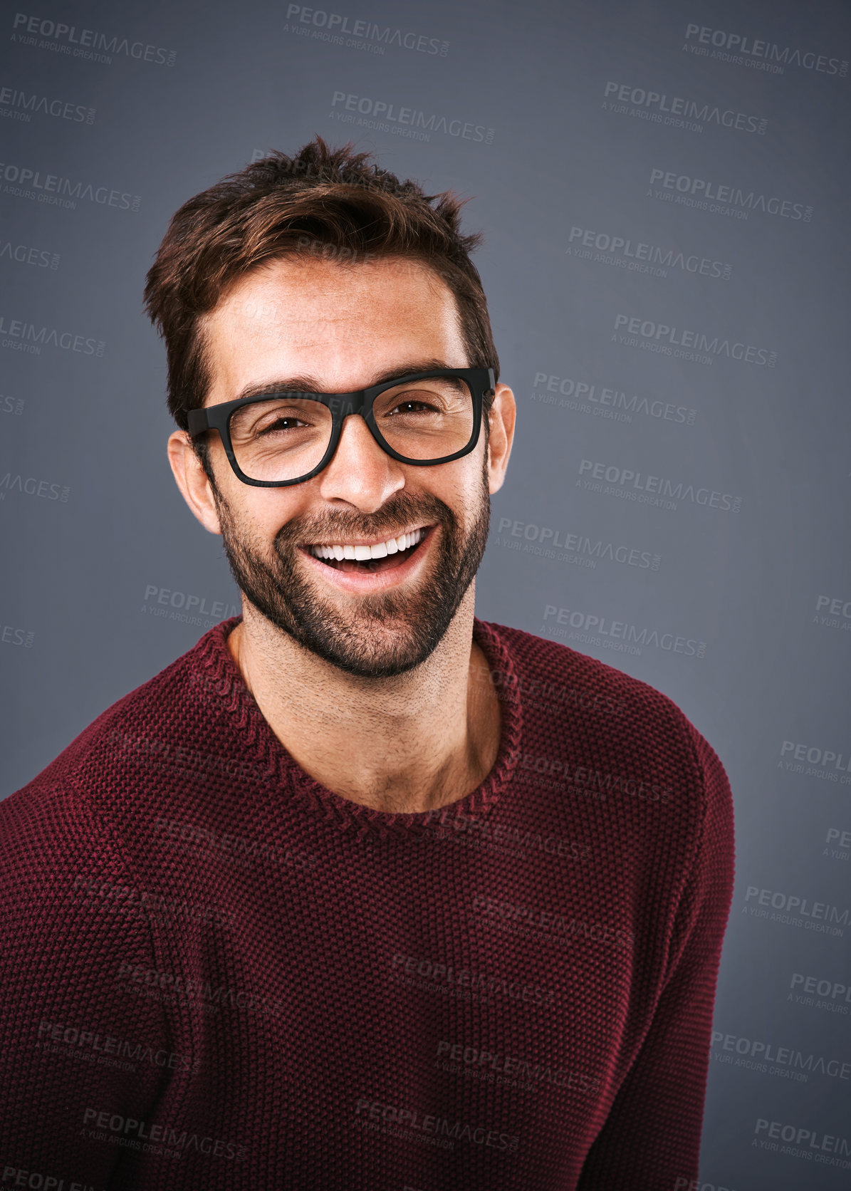 Buy stock photo Studio shot of a handsome and happy young man posing against a gray background