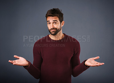 Buy stock photo Studio shot of a handsome young man gesturing in indifference against a gray background