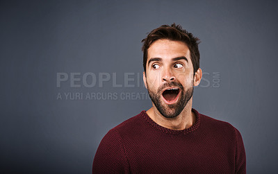 Buy stock photo Studio shot of a handsome young man looking surprised against a gray background