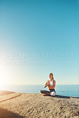 Buy stock photo Shot of a young woman doing yoga at the beach