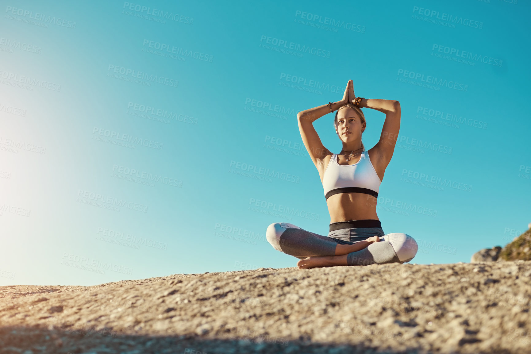 Buy stock photo Shot of a young woman doing yoga at the beach