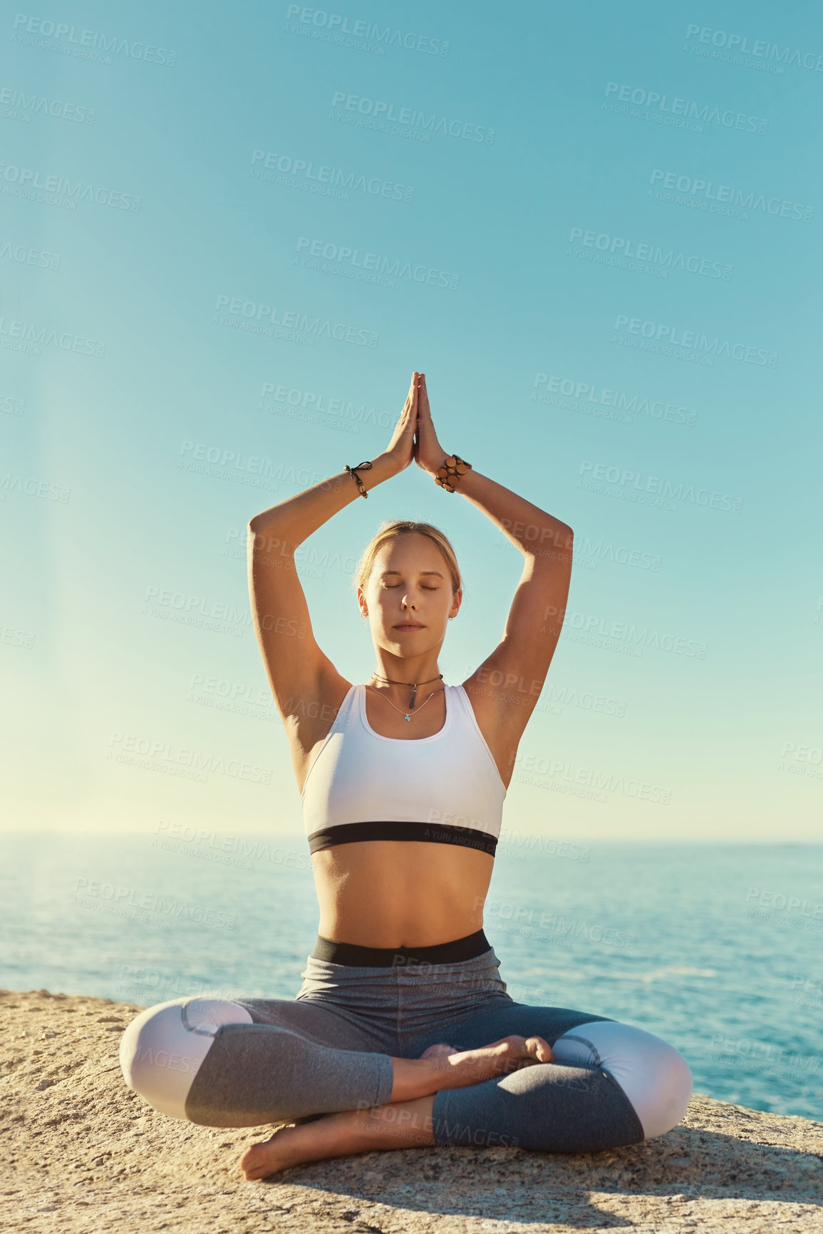 Buy stock photo Shot of a young woman doing yoga at the beach