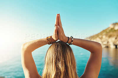 Buy stock photo Rearview shot of a young woman practicing yoga on the beach