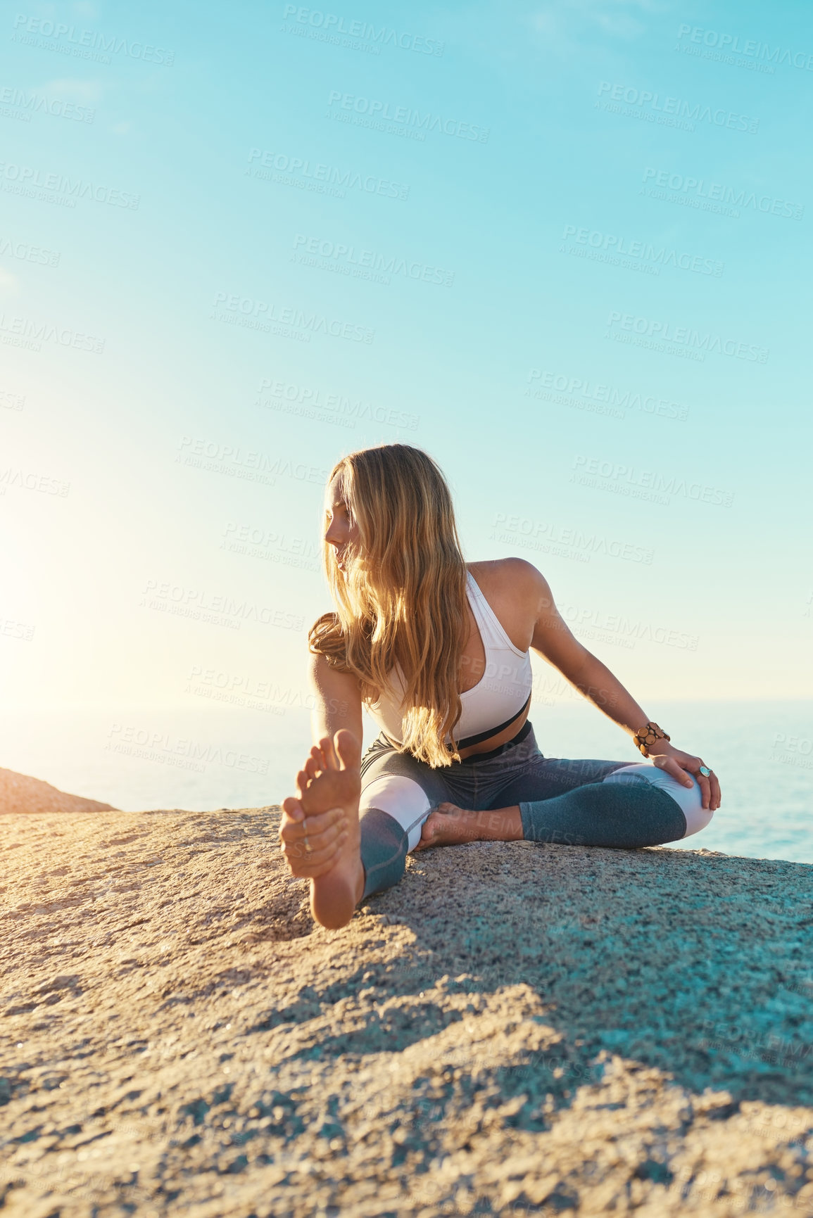 Buy stock photo Shot of an athletic young woman practicing yoga on the beach