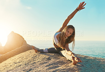 Buy stock photo Shot of an athletic young woman practicing yoga on the beach