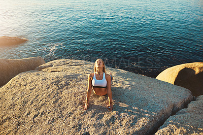 Buy stock photo Shot of an athletic young woman practicing yoga on the beach