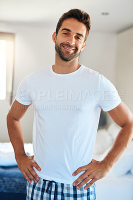 Buy stock photo Cropped portrait of a handsome young man standing with his hands on his hips in his bedroom at home