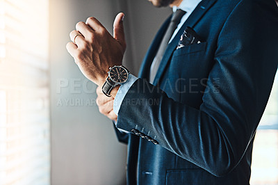 Buy stock photo Cropped shot of an unrecognizable young man putting on his watch in his bedroom at home