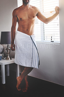 Buy stock photo Cropped shot of an unrecognizable young man standing in a in his bedroom towel at home