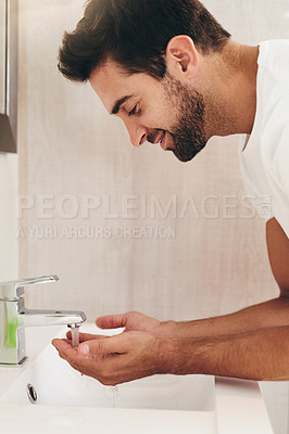 Buy stock photo Cropped shot of a handsome young man washing his face in his bathroom at home