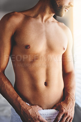 Buy stock photo Cropped shot of an unrecognizable man standing in a towel in his bedroom at home