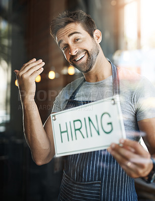 Buy stock photo Portrait of a handsome young man hanging up a hiring sign on the door of his store