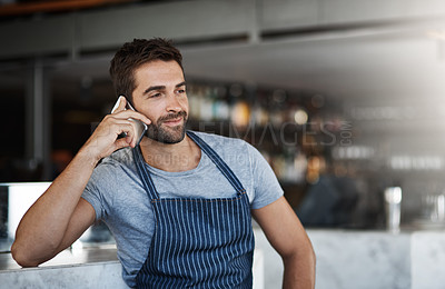 Buy stock photo Shot of a young man using a mobile phone while working at a coffee shop