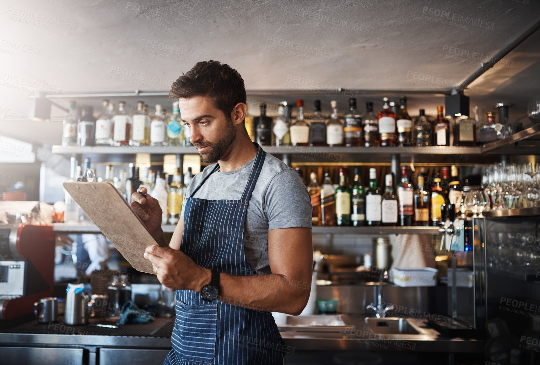 Buy stock photo Bartender, writing and clipboard for restaurant management with stock, inventory or check for liquor. Person, barman and checklist with thinking, order or reading for alcohol, invoice or notes at pub