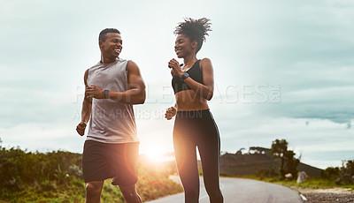 Buy stock photo Shot of a sporty young couple exercising together outdoors