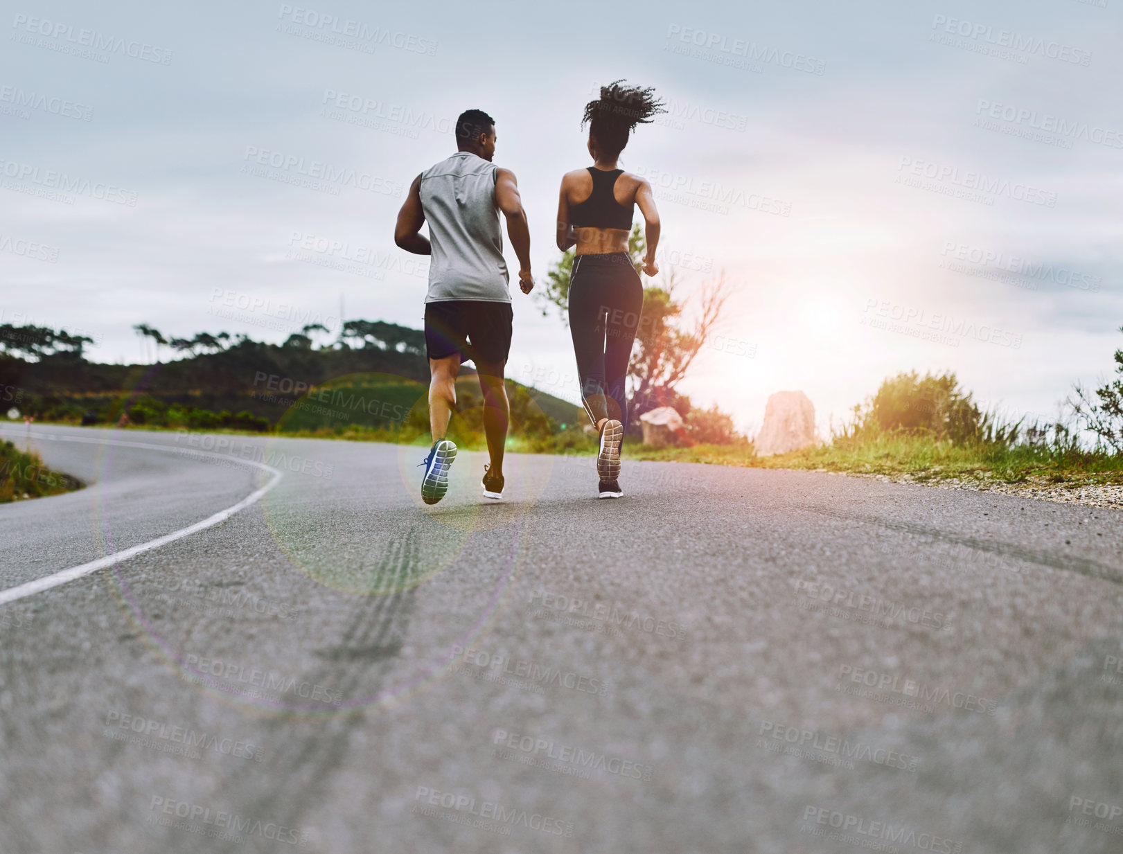 Buy stock photo Rearview shot of a sporty young couple exercising together outdoors