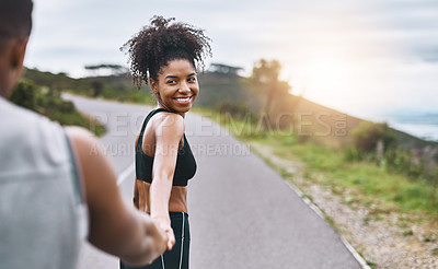 Buy stock photo Shot of a sporty young woman leading her partner by the hand while exercising outdoors