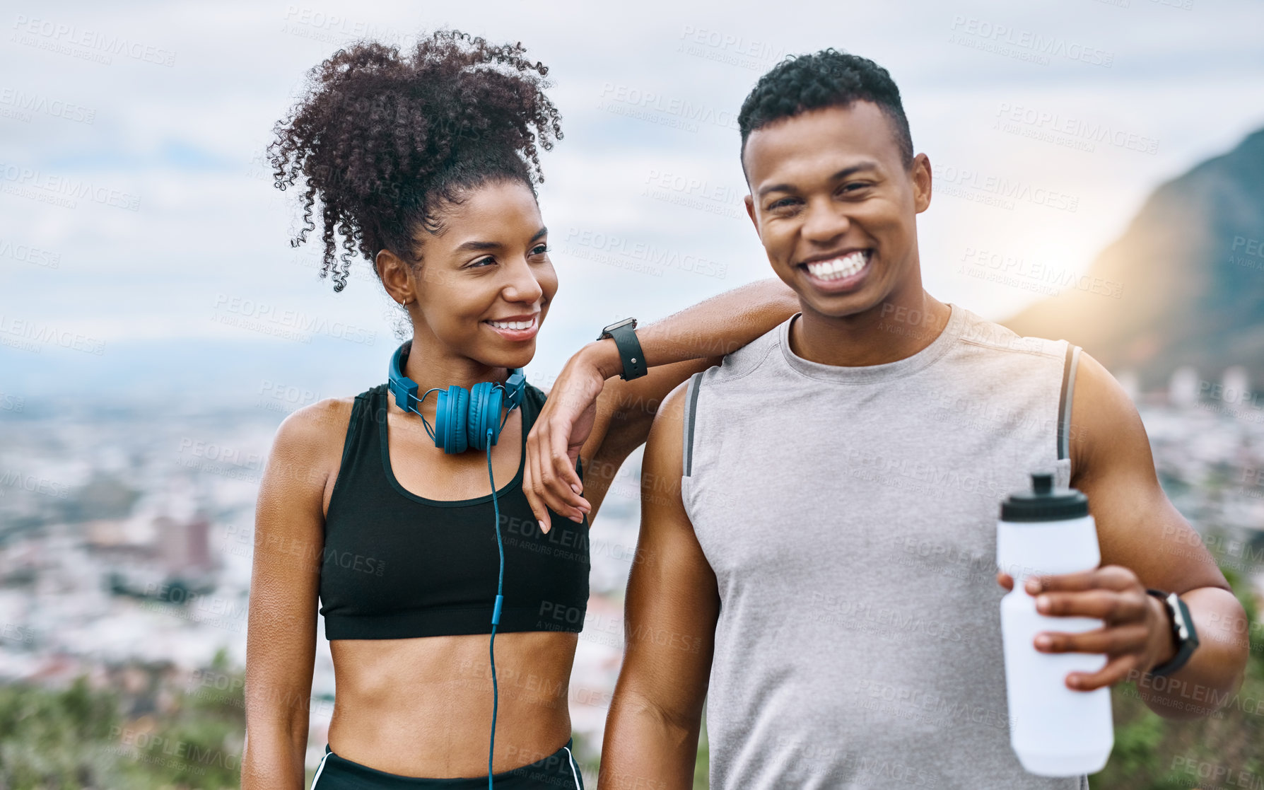 Buy stock photo Shot of a sporty young couple taking a break while exercising outdoors