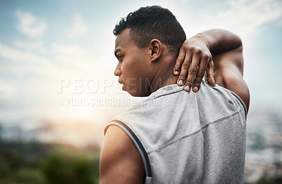 Buy stock photo Rearview shot of a sporty young man touching his neck while exercising outdoors