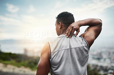 Buy stock photo Rearview shot of a sporty young man touching his neck while exercising outdoors