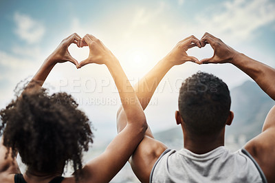 Buy stock photo Rearview shot of a sporty young couple making heart shapes with their hands while exercising outdoors