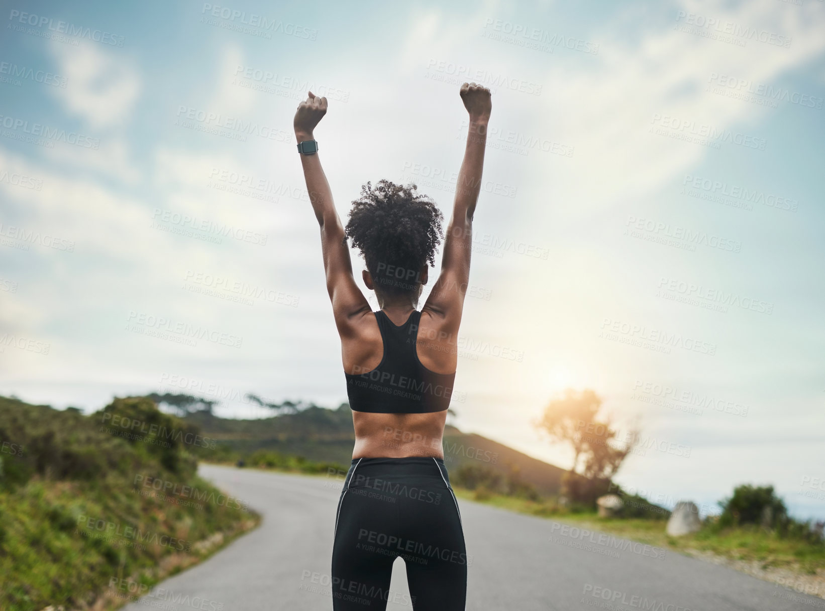 Buy stock photo Rearview shot of an unrecognizable young sportswoman cheering in celebration outside