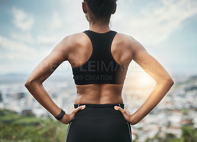 Buy stock photo Rearview shot of an unrecognizable young sportswoman standing with her hands on her hips outside