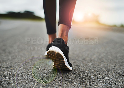Buy stock photo Rearview shot of an unrecognizable young sportswoman's running shoes outside