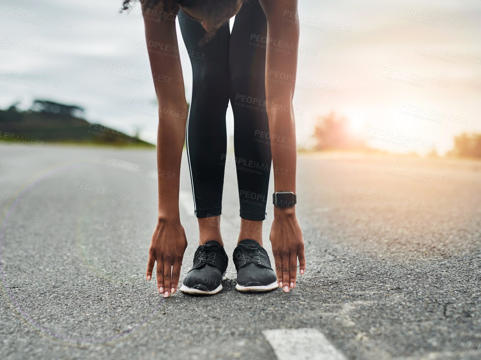 Buy stock photo Cropped shot of an unrecognizable young sportswoman warming up for a workout outdoors