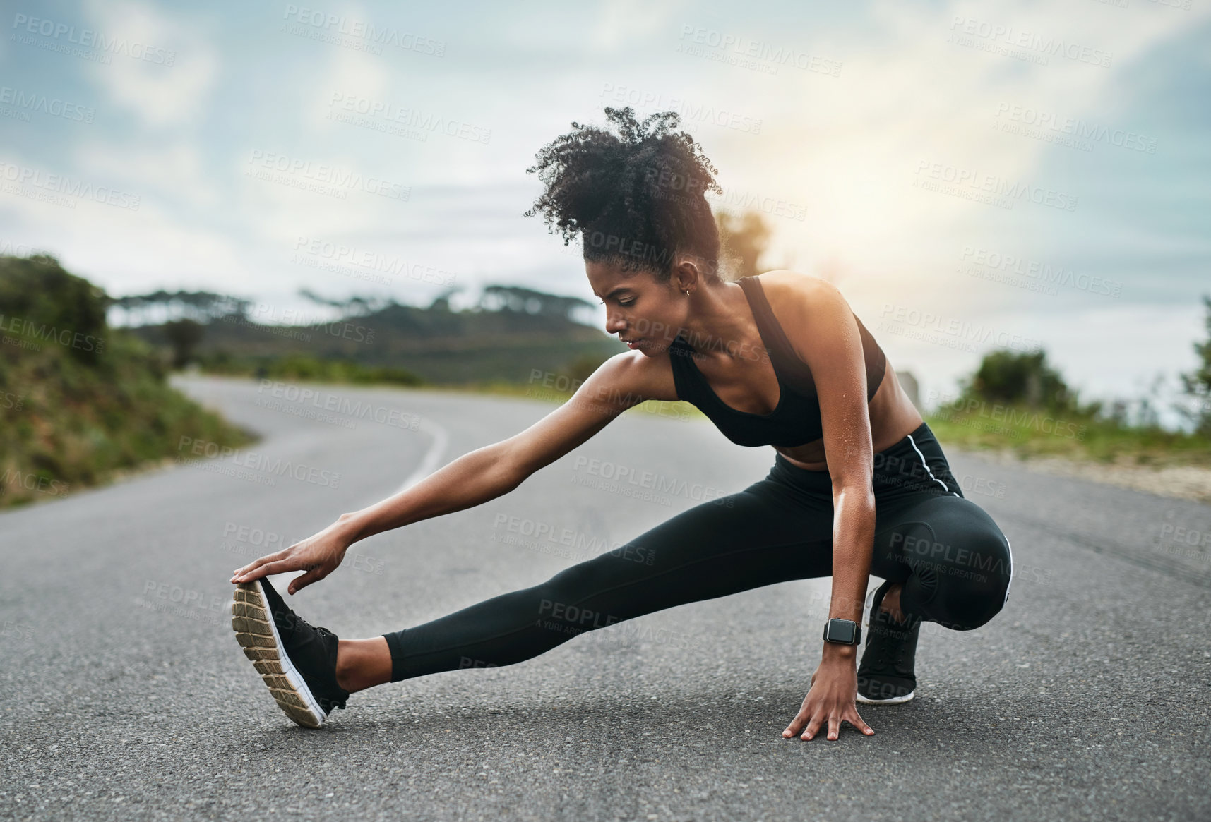 Buy stock photo Full length shot of an attractive young sportswoman warming up for a workout outdoors