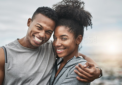 Buy stock photo Cropped portrait of an affectionate and athletic young couple standing with their arms around one another outdoors