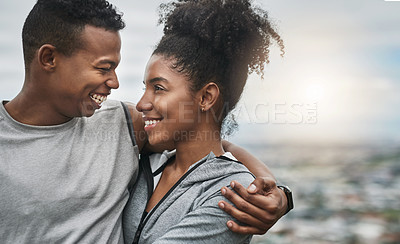 Buy stock photo Cropped shot of an affectionate and athletic young couple standing with their arms around one another outdoors