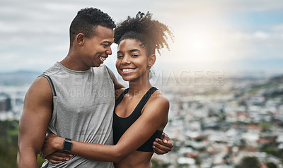 Buy stock photo Cropped shot of an affectionate and athletic young couple standing with their arms around one another outdoors